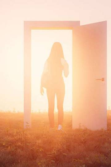 woman standing in illuminated door frame
